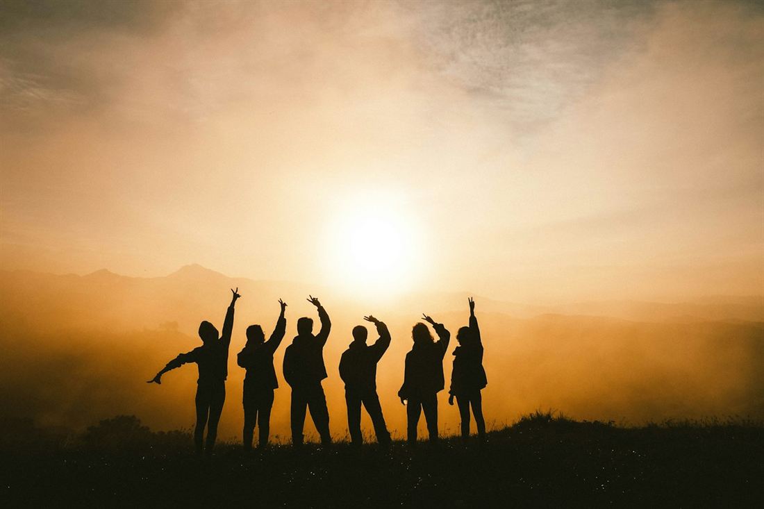 Un gruppo festeggia al tramonto in montagna